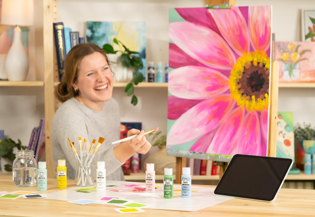 Woman painting flower on easel with FolkArt